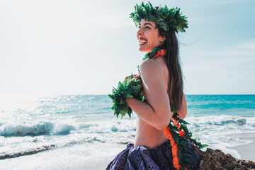 Smiling young woman showing big smile on the beach. Lady in Hawaiian attire to dance hula dance laughs out loud. Happy Caucasian woman waiting to dance.