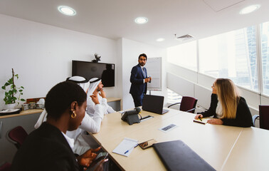 Wall Mural - Multiethnic western and middle eastern business team working together in an office of Dubai. Sales people and employees at work on new projects