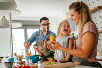 Wall Mural - Happy family preparing healthy food together in kitchen