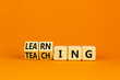 Learning or teaching symbol. Turned wooden cubes and changed the word Teaching to Learning. Beautiful orange table orange background. Educational learning or teaching concept. Copy space.