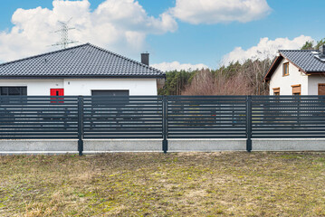 Wall Mural - Modern anthracite panel fencing, visible spans and a fence foundation connector, view from the garden.