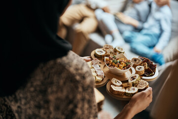 Wall Mural - Close-up of Muslim woman serves dessert to her family at home.