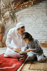 Poster - Muslim father kisses his daughter who is reading from Quran at home.