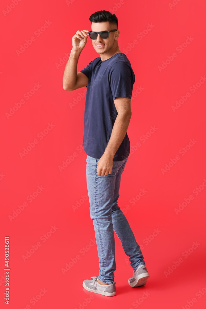 Handsome young man in stylish t-shirt on color background