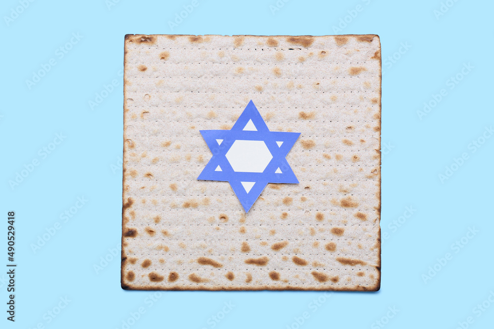 Jewish flatbread matza with David star for Passover on blue background