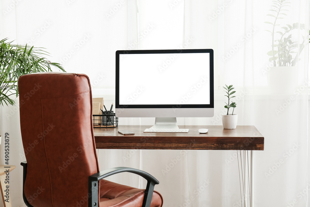 Stylish workplace with modern computer in light room interior