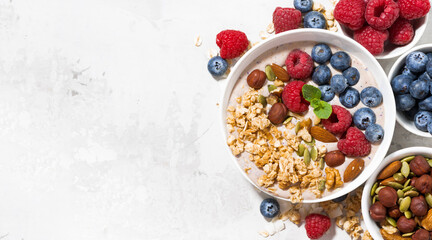 Wall Mural - muesli with yogurt and berries for breakfast on white background, top view