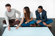 © Arnéll K/peopleimages.com - Every opinion matters. Studio shot of a group of young people sitting on the floor and working on blank paper.