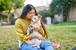 © ADDICTIVE STOCK - Woman hugging dog on lawn