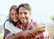 © Stigur/peopleimages.com - No place like nature. A young couple smiling with a tent in the background.