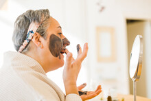 Woman Applying Mask On Face