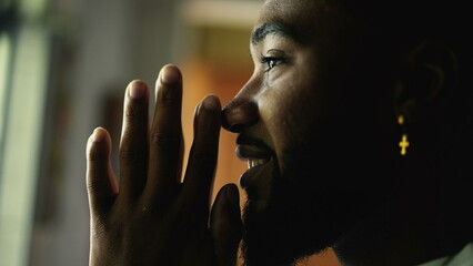 Wall Mural - A spiritual black man praying with hands together