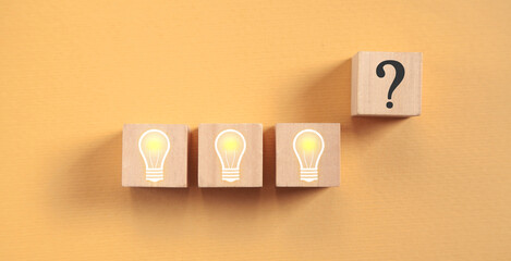 Wall Mural - Light bulb and question mark on wooden cube.