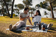© Alberto - Happy young couple enjoying a glass of wine on a romantic picnic in a park.