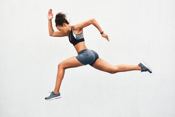 Poster - Giving it all shes got. Full length shot of an attractive young female athlete running along the track.