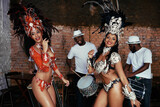 The thrill of performing live. Portrait of two beautiful samba dancers and their band.