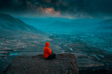 Wall Mural - person sitting on the top of the mountain meditating or praying under the starry night with milky wa
