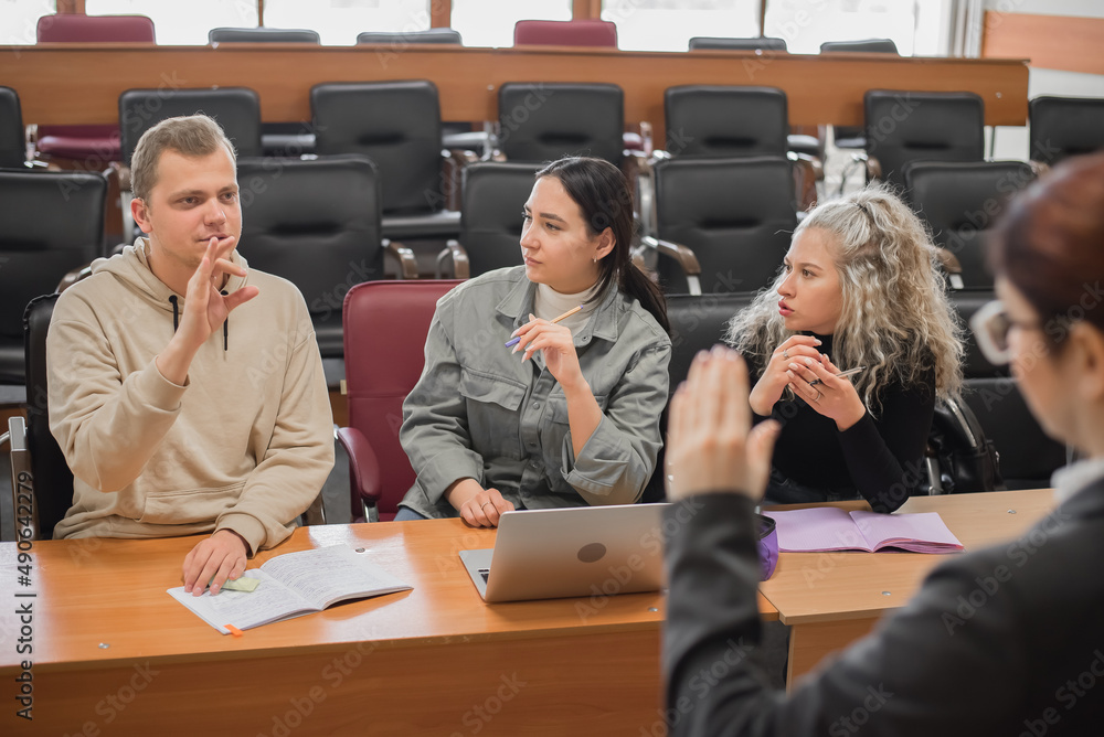 The teacher and students communicate in sign language in the classroom ...