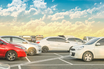 Wall Mural - Car parked in large asphalt parking lot with beautiful cloud and sunset sky background