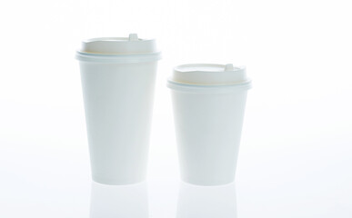 Two take away paper cups with closed caps against white background