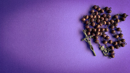 Wall Mural - Top view of Holy Rosary on purple cover background.