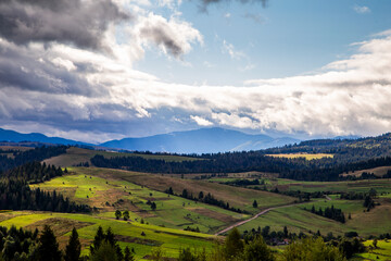 hills with forests in the countryside on a summer cloudy day. mountains landscape background.
