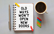 The word Old Ways won't open New Doors on torn paper on red notepad.