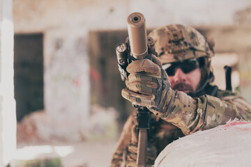 A bearded soldier in uniform of special forces in a dangerous military action in a dangerous enemy area. Selective focus 