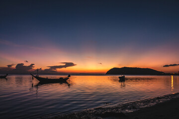 Wall Mural - silhouettes of fishing boats on the sea at a beautiful sunset