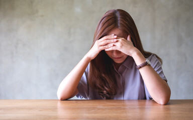 Wall Mural - A young asian woman feeling sad and stressed, sick and headache at home