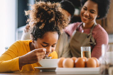 Happy african american family preparing healthy food together in kitchen