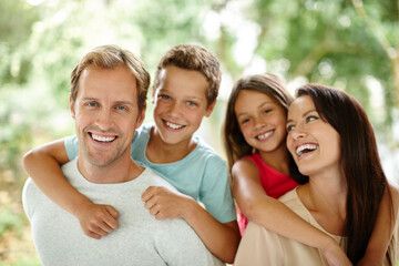 Wall Mural - Making happy memories together. Portrait of a happy family of four spending time together outdoors.