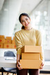 © David - Startup SME small business entrepreneur SME of freelance Asian woman using a laptop with box Cheerful success Asian woman her hand lifts up online marketing packaging box and delivery SME idea concept