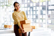 © David - Startup SME small business entrepreneur SME of freelance Asian woman using a laptop with box Cheerful success Asian woman her hand lifts up online marketing packaging box and delivery SME idea concept