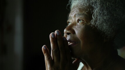 A senior African woman praying to God in meditation