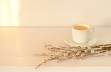Cup Of Black Coffee And Flowering Willow Branches On A White Wooden Table. Morning Spring Coffee, Copy Space