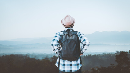 Wall Mural - African backpack traveler man looking a sunrise ,fog and landscape on a top of a mountain