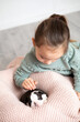 © Анна Брусницына - A cute girl strokes a newborn Boston Terrier puppy on her lap. Lifestyle. A child and a dog.