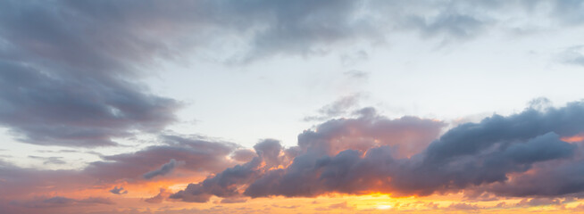 dark clouds and shining sun at dusk