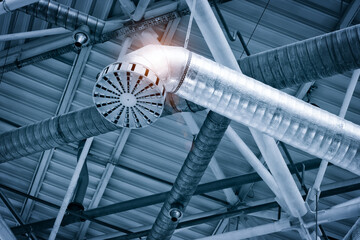 Poster - Ventilation pipes in silver insulation material hanging from the ceiling inside new building.