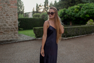 Wall Mural - Young beautiful model in black dress and with sunglasses