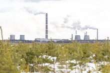 Smoking City Chimneys. Smoking Factory Against The Background Of Small Christmas Trees
