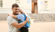 © Pixel-Shot - Father hugging his little son near school outdoors