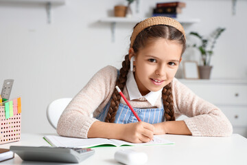 Sticker - Little girl writing in copybook while studying with online tutor at home