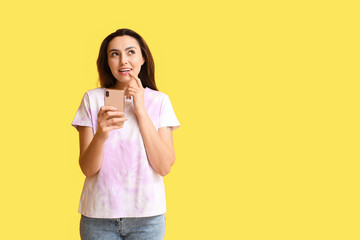 Sticker - Dreamy woman with mobile phone checking e-mail message on yellow background