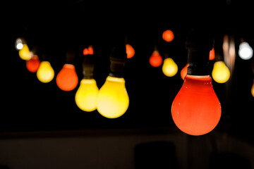 Wall Mural - a festoon with red and yellow light bulbs lit up during a party celebration to create festive mood