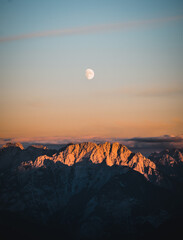 Wall Mural - beautiful shot of a growing moon in the dolomites mountains during the sunrise