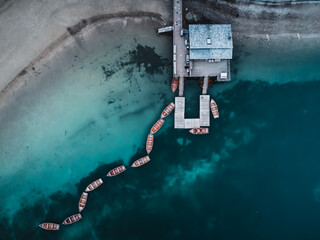 Poster - Aerial view of a beautiful lake with crystal azure water with moored boats in South Tyrol