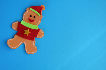 Canvas Print - Artificial Christmas gingerbread man over the blue surface