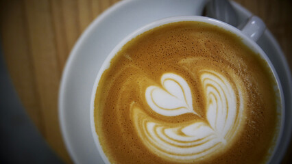 Wall Mural - High angle shot of a cup of latte on a wooden table